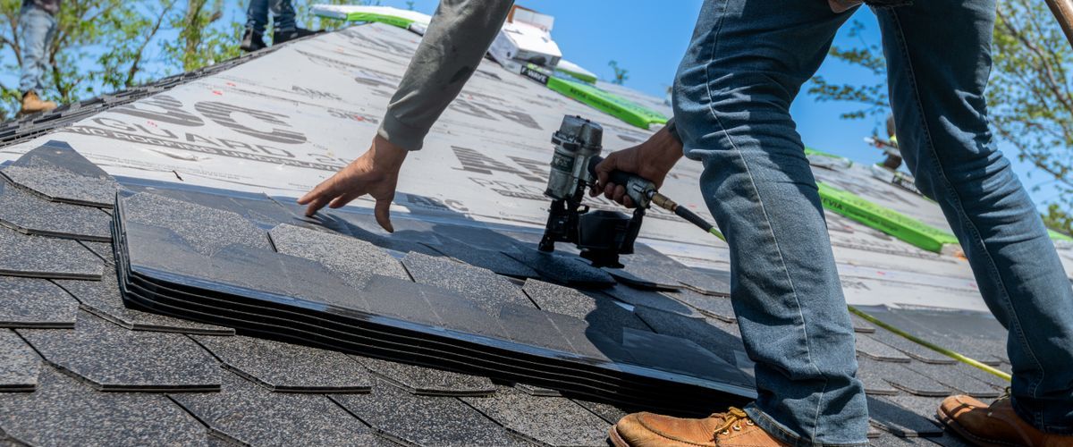 Roofer installing shingles reinforced with roofing scrim